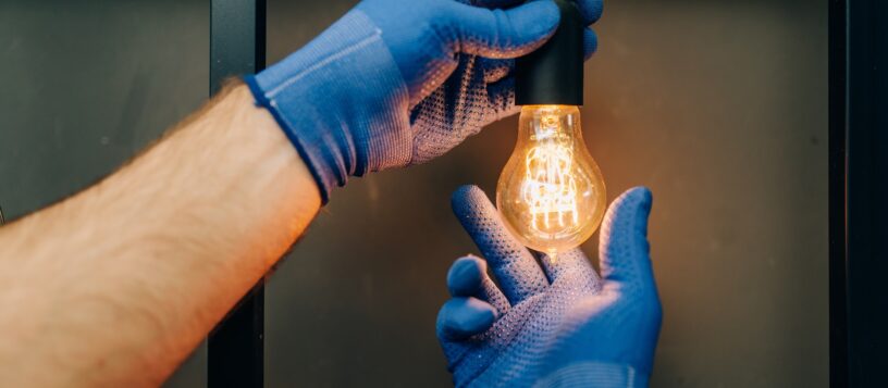 Electrician changes the light bulb, handyman